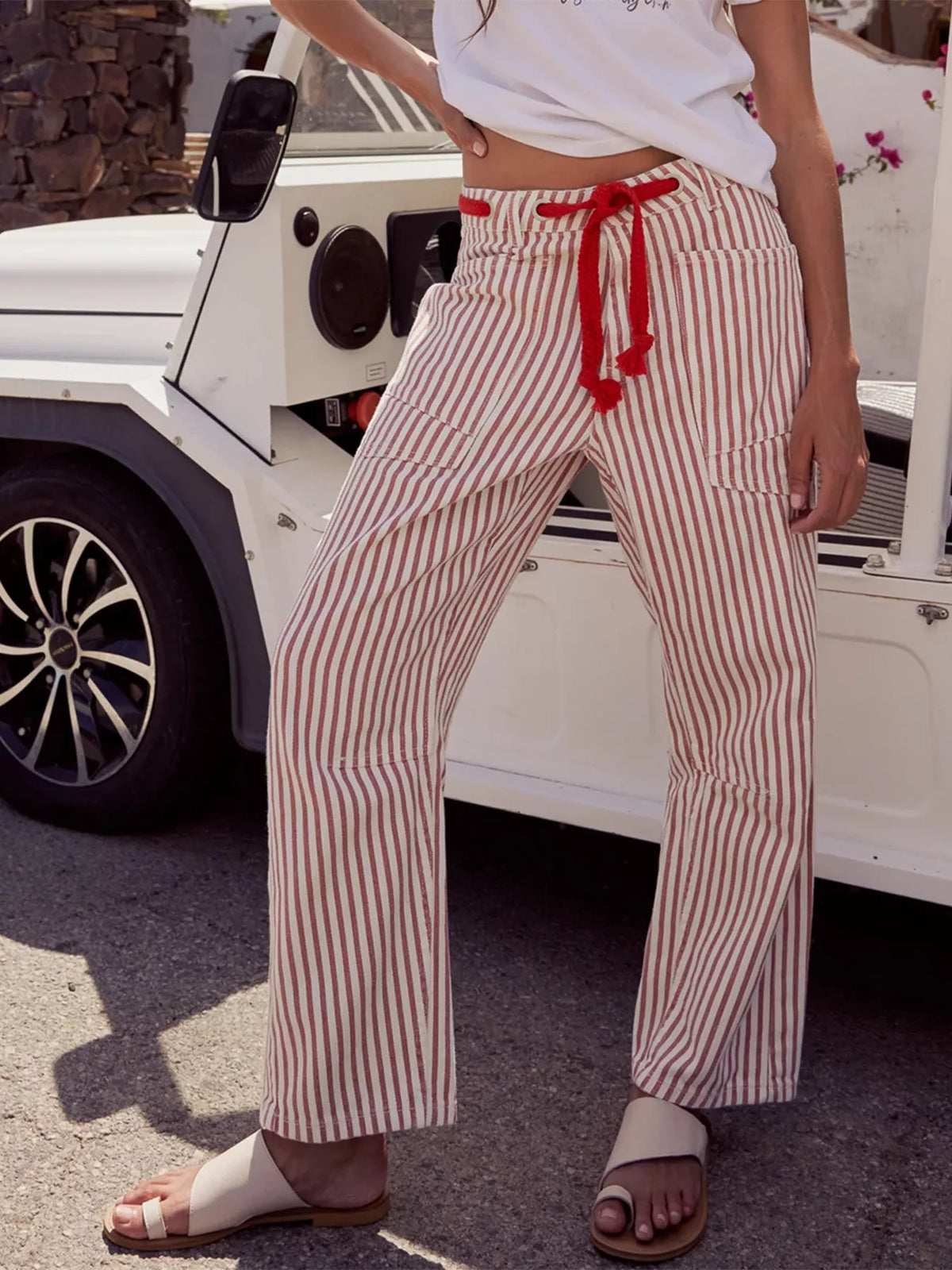 Pinstripe red crop barrel.jeans model poses outside a white jeep 